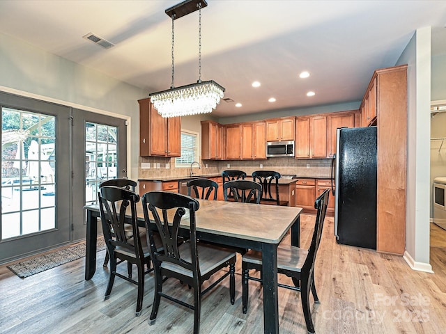 dining space with sink and light wood-type flooring