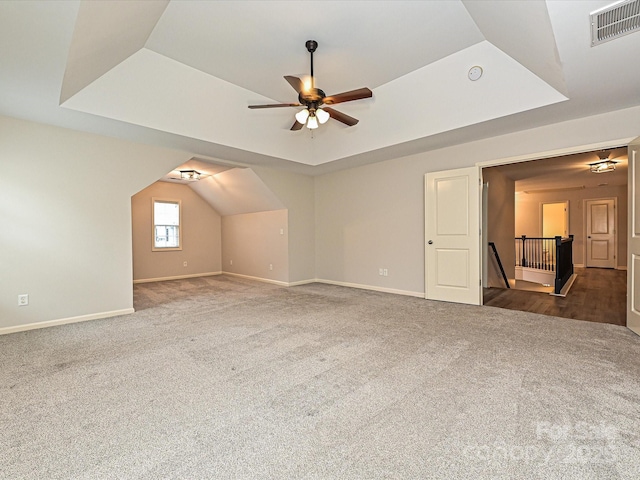 bonus room with ceiling fan and dark colored carpet