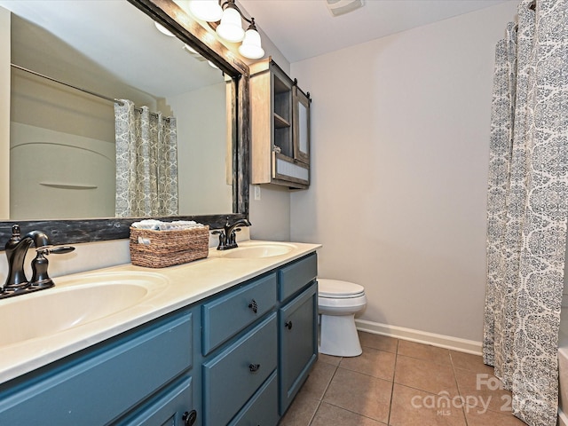 bathroom featuring tile patterned flooring, vanity, and toilet