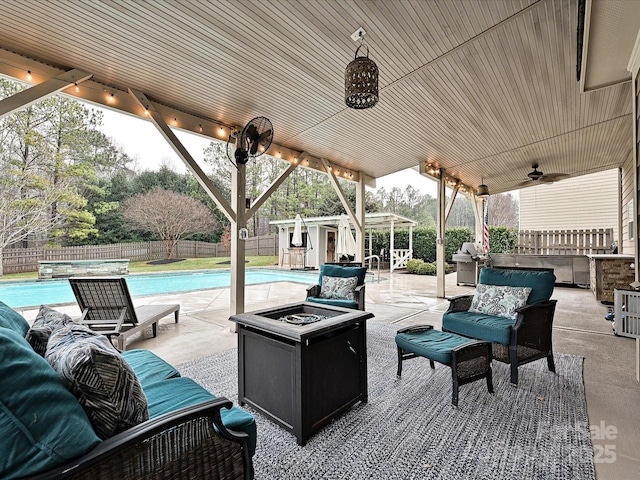 view of patio with an outbuilding, a grill, a fenced in pool, and an outdoor living space with a fire pit