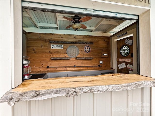 interior space featuring wood counters, wooden walls, and ceiling fan