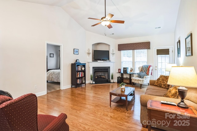 living room with wood-type flooring, high vaulted ceiling, and ceiling fan