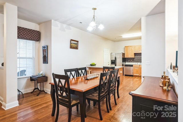 dining room featuring a notable chandelier and light hardwood / wood-style floors