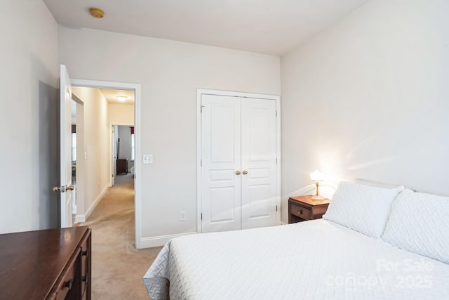 bedroom with light colored carpet and a closet