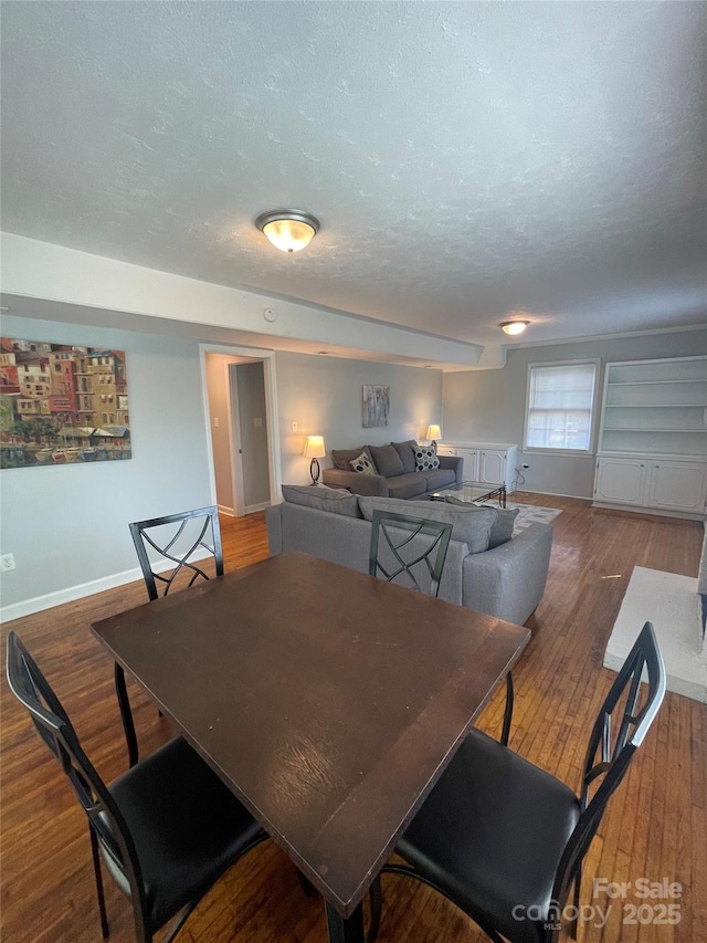 dining area with dark wood-type flooring and a textured ceiling