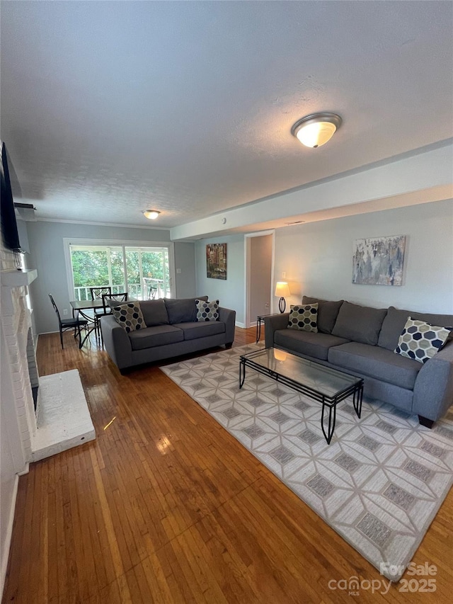 living room featuring hardwood / wood-style flooring, a textured ceiling, and a fireplace