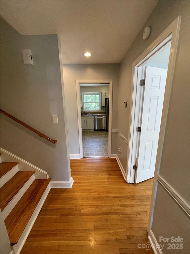 corridor featuring sink and light hardwood / wood-style floors