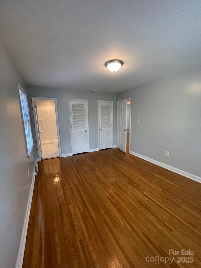 unfurnished bedroom with dark wood-type flooring