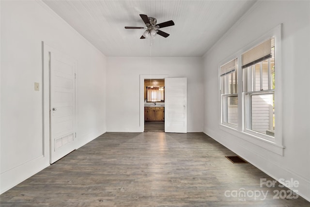 empty room featuring dark wood finished floors, visible vents, and a ceiling fan