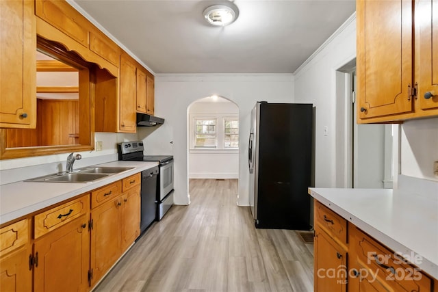 kitchen featuring a sink, extractor fan, arched walkways, light countertops, and appliances with stainless steel finishes