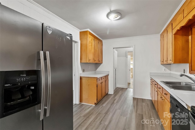 kitchen with dishwasher, a sink, stainless steel refrigerator with ice dispenser, light wood-style floors, and light countertops
