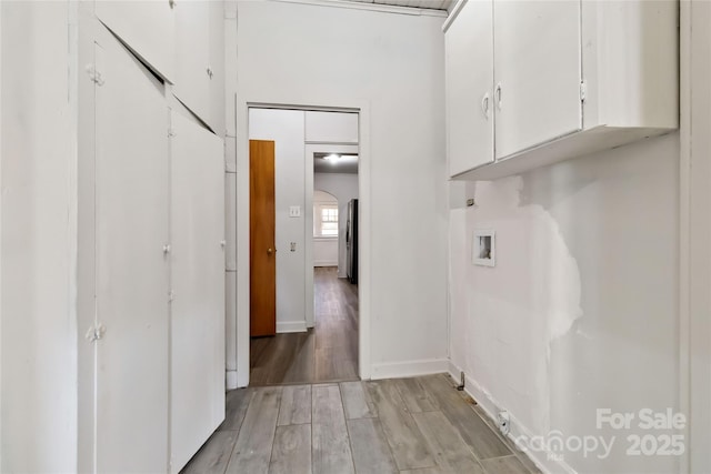 laundry area featuring cabinet space, light wood finished floors, baseboards, and hookup for a washing machine