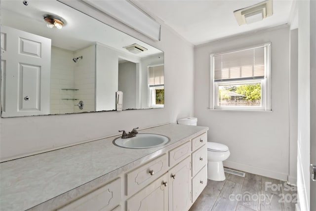full bath with toilet, wood finished floors, visible vents, walk in shower, and vanity