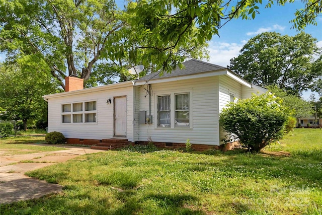 view of front of property featuring a front lawn, a chimney, and crawl space