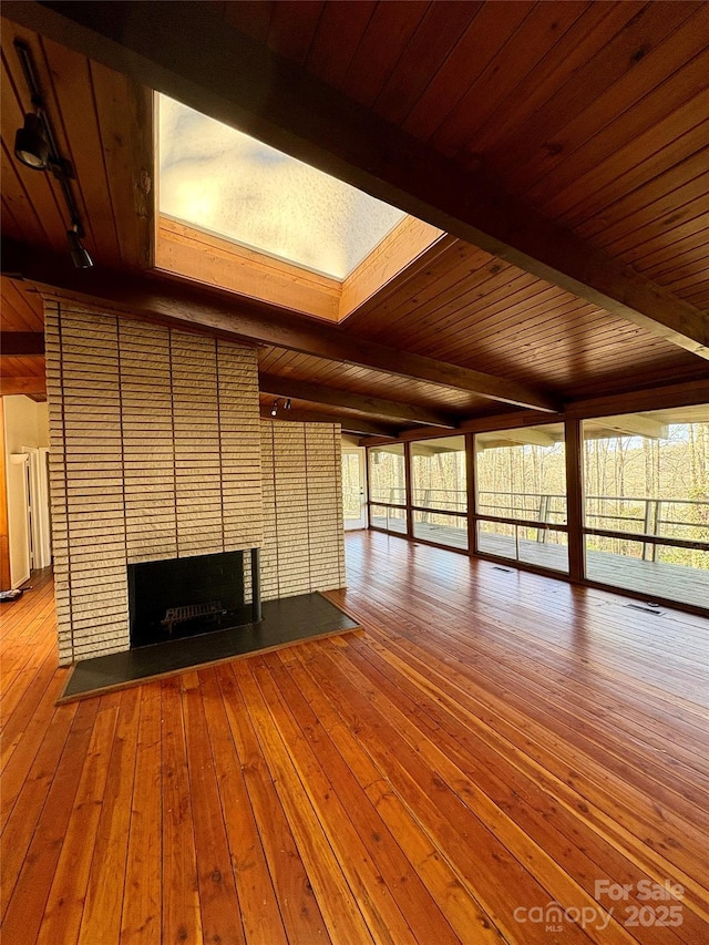 unfurnished living room with a fireplace, wood-type flooring, wooden ceiling, and beamed ceiling