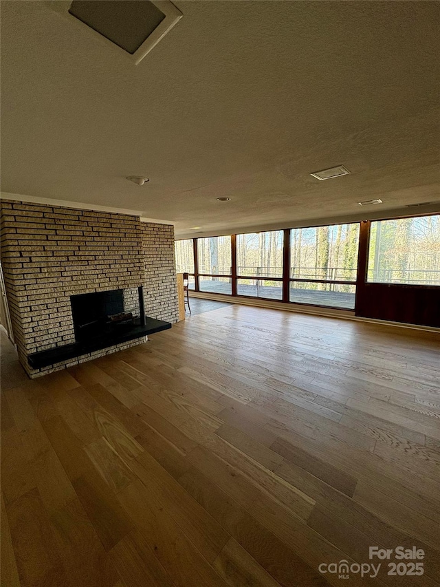 unfurnished living room with a brick fireplace and wood-type flooring