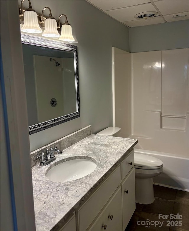 full bathroom featuring tile patterned floors, toilet, bathing tub / shower combination, a paneled ceiling, and vanity