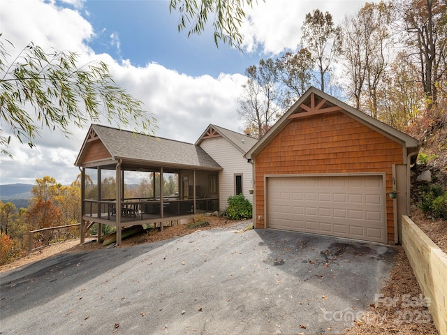 view of front facade with a garage and a sunroom