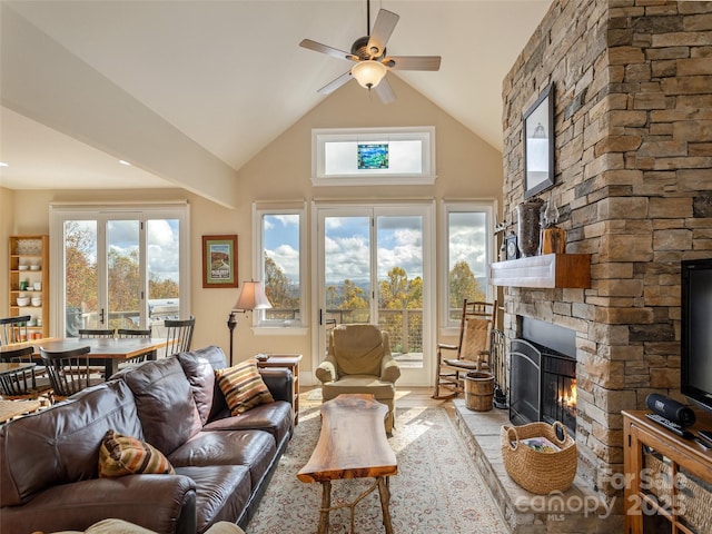 living room with ceiling fan, lofted ceiling, a fireplace, and light hardwood / wood-style flooring