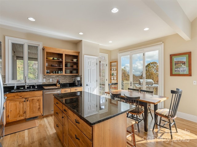 kitchen featuring dishwasher, a center island, sink, and light wood-type flooring