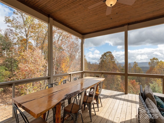 sunroom with ceiling fan and wooden ceiling