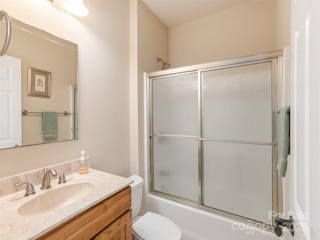 full bathroom featuring bath / shower combo with glass door, vanity, and toilet