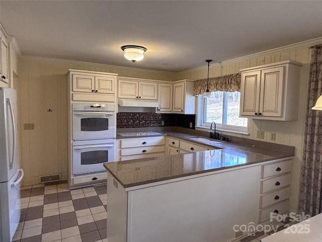 kitchen featuring sink, hanging light fixtures, ornamental molding, kitchen peninsula, and white appliances