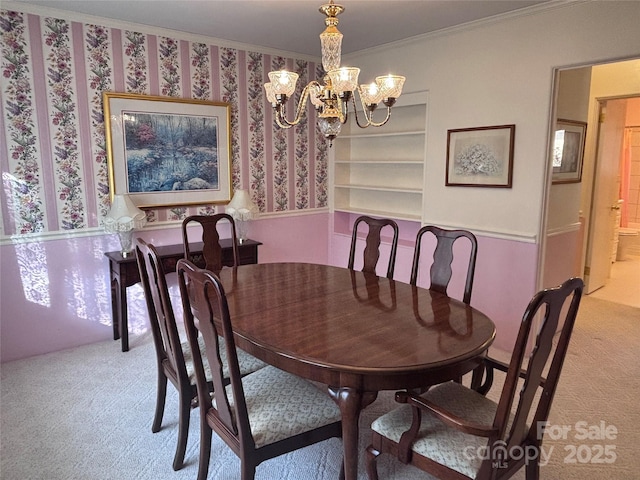 carpeted dining space with crown molding, a notable chandelier, and built in shelves