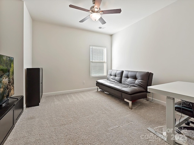 living area featuring light colored carpet and ceiling fan