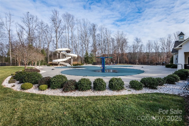 view of swimming pool featuring a yard