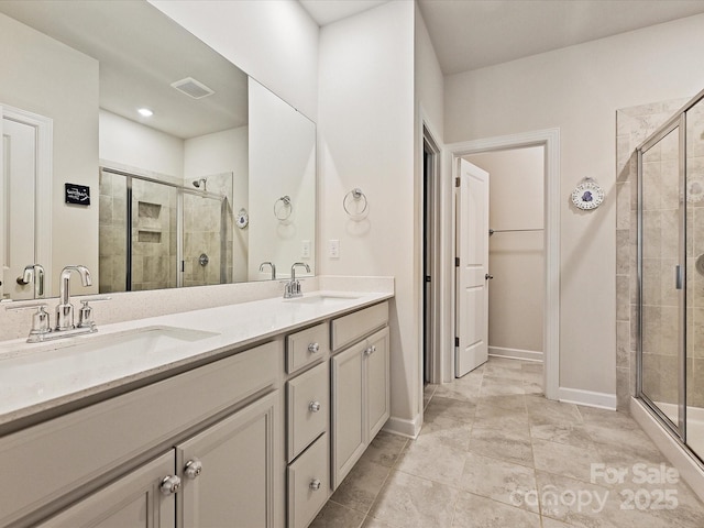 bathroom with a shower stall, double vanity, visible vents, and a sink