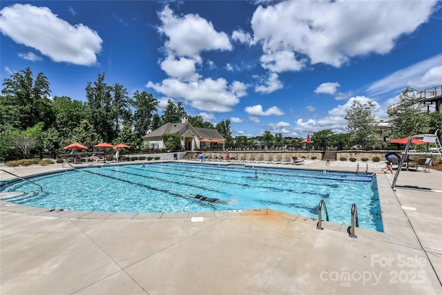 pool featuring fence and a patio area