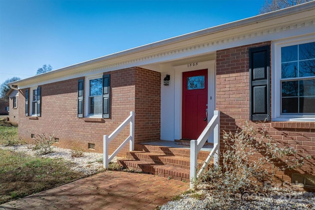 entrance to property with crawl space and brick siding