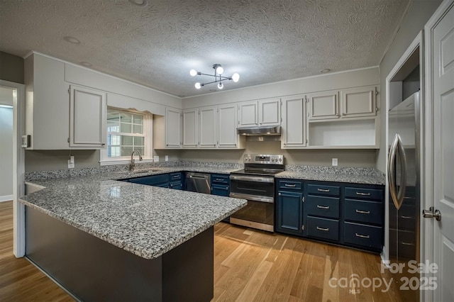 kitchen featuring sink, white cabinetry, stainless steel appliances, blue cabinets, and kitchen peninsula