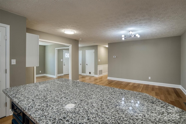 unfurnished room featuring a textured ceiling and light wood-type flooring