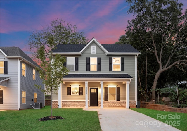 view of front of home featuring central AC unit, a yard, and covered porch