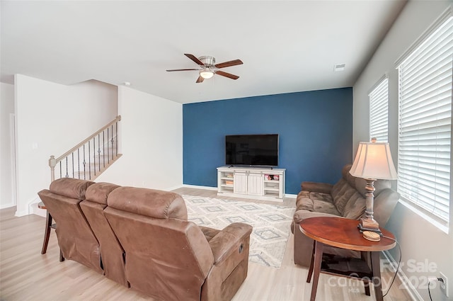 living room with plenty of natural light, ceiling fan, and light wood-type flooring