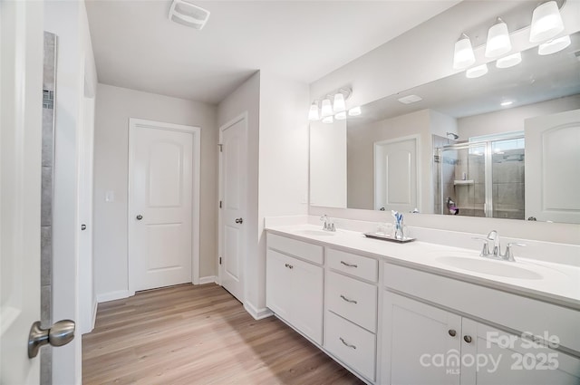 bathroom featuring vanity, hardwood / wood-style floors, and walk in shower