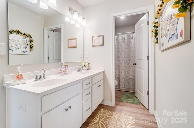 bathroom with walk in shower, vanity, toilet, and wood-type flooring