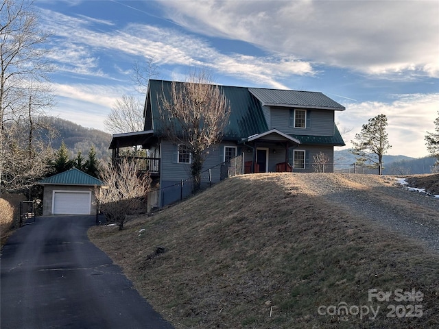 view of front of property with a garage, an outdoor structure, and a mountain view