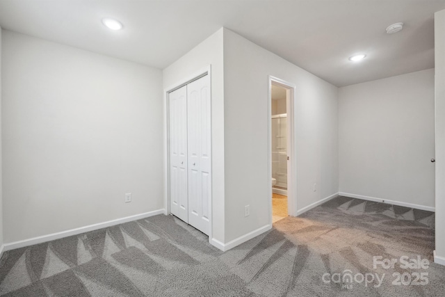 unfurnished bedroom with carpet flooring, connected bathroom, and a closet