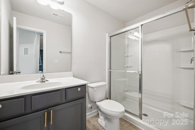 bathroom featuring a shower with door, vanity, and toilet