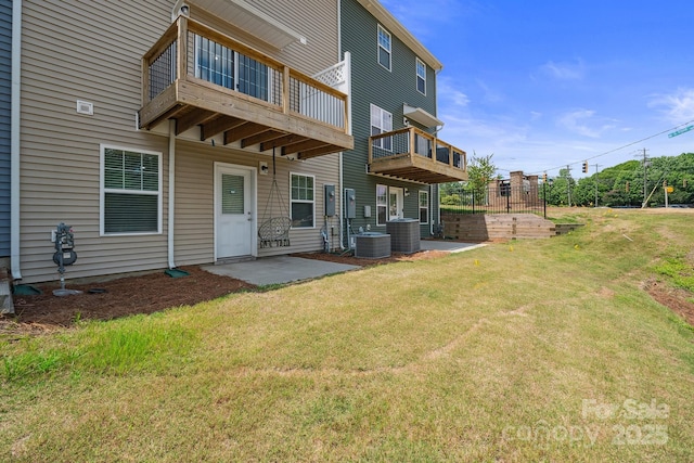 back of house featuring central AC unit, a patio area, and a lawn