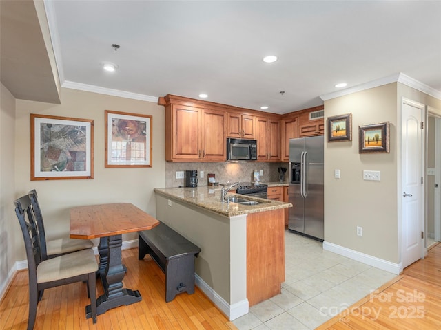 330 Bowling Park Rd, Asheville, NC 28803 - kitchen featuring kitchen peninsula, sink, breakfast area, stainless steel appliances, and light stone countertops