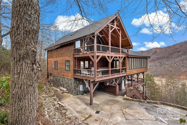 rear view of house with a deck with mountain view