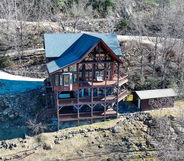 back of house with a wooden deck and an outbuilding