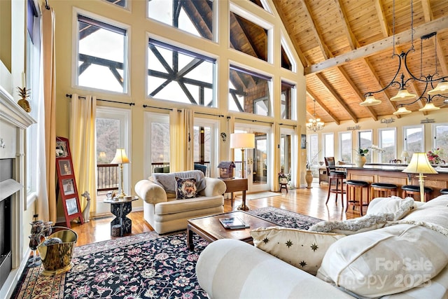 living room featuring wood ceiling, hardwood / wood-style flooring, beam ceiling, high vaulted ceiling, and a chandelier