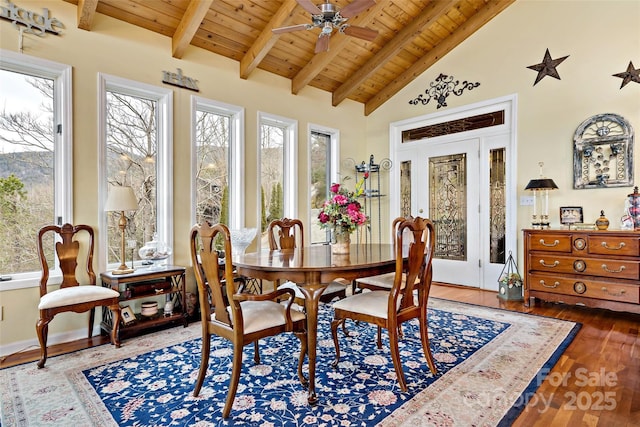 dining room with beamed ceiling, plenty of natural light, hardwood / wood-style floors, and wooden ceiling