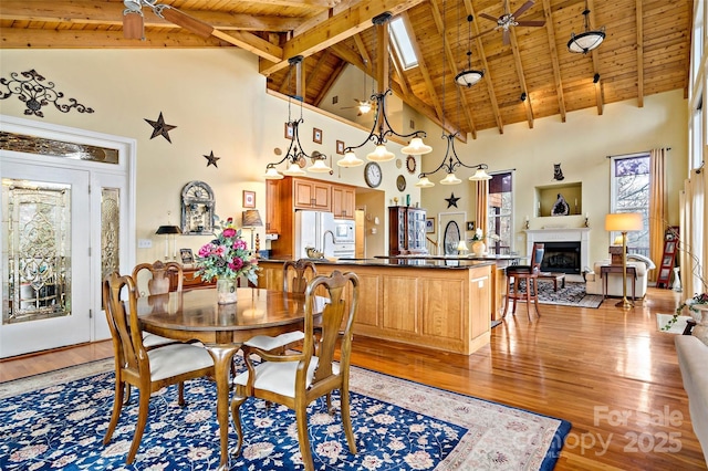 dining area with ceiling fan, wood-type flooring, wooden ceiling, and high vaulted ceiling