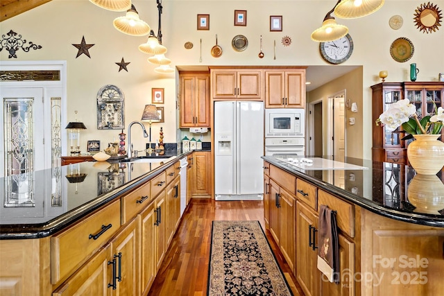 kitchen featuring dark wood-type flooring, sink, a kitchen island, pendant lighting, and white appliances